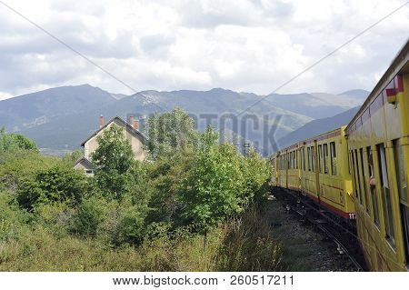 Latour De Carol - September 4, 2018: The Small Yellow Train Of The Pyrenees Crossing A Beautiful Mou