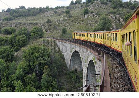 Latour De Carol - September 4, 2018: The Small Yellow Train Of The Pyrenees Crossing A Beautiful Mou