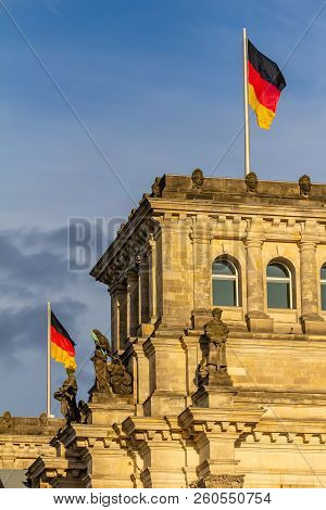 Federal Republic Of Germany, German National Flag At The Parliament Building Waving On The Blue Sky 