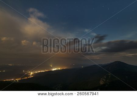 Beautiful Summer Night Panorama In Mountains. Wide View Of Starry Dark Blue Cloudy Sky Over Magnific