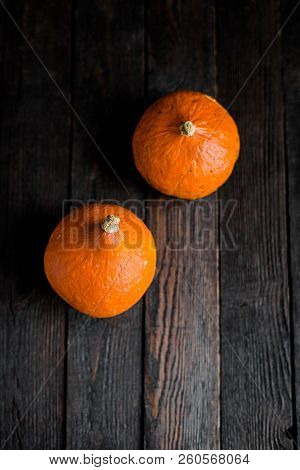 Small Orange Pumpkins On The Dark Wooden Table, Autumn Concept, Harrvest Time. Copy Space.