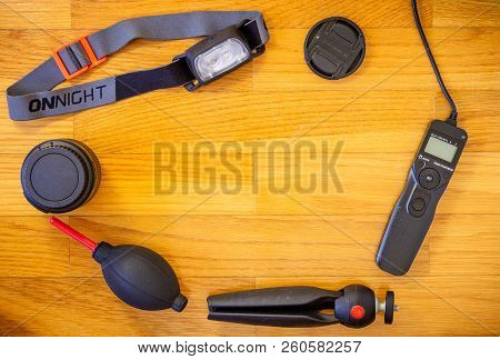 A Wooden Background With A Set Of Photography Accessories Consisting Of A Lens Cap, A Intervalometer