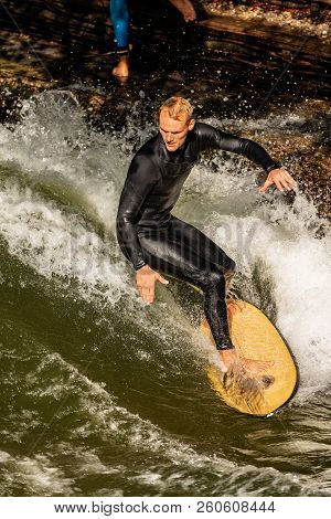 Munich, Germany - Sept 8, 2018: A Man Surfing In The Waves Of The Eisbach River In Downtown Of Munic