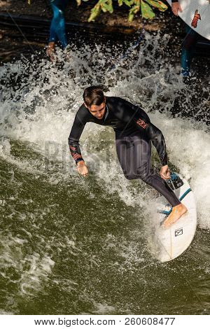 Munich, Germany - Sept 8, 2018: A Man Surfing In The Waves Of The Eisbach River In Downtown Of Munic