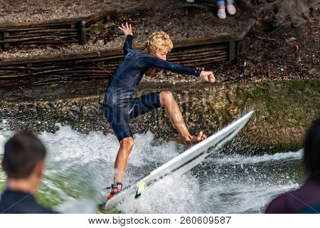 Munich, Germany - Sept 8, 2018: A Man Surfing In The Waves Of The Eisbach River In Downtown Of Munic