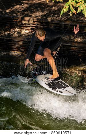 Munich, Germany - Sept 8, 2018: A Man Surfing In The Waves Of The Eisbach River In Downtown Of Munic