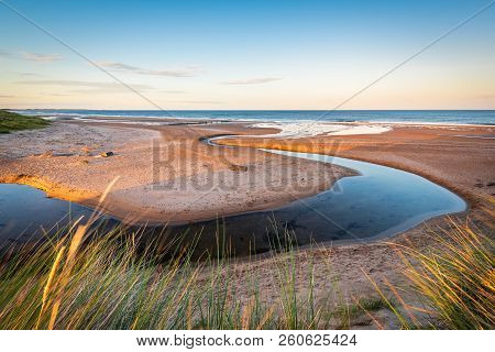 Dunbar Burn Meanders Across Druridge Bay, A Seven Mile Long Beach In Northumberland Between Amble To