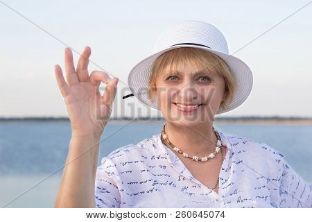 Happy Elderly Lady Woman In White Hat Shows Okey Geste