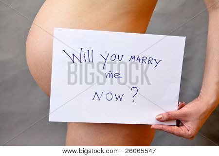 Pregnant woman holding tablet with question: âWill you marry me now ?â