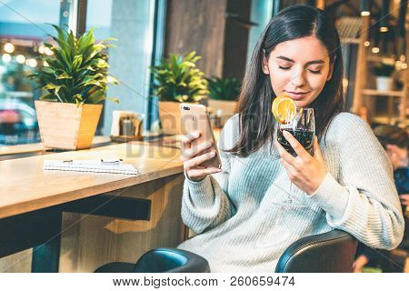 Christmas Concept - Happy Young Woman With Glass Of Wine Or Glintwine Checking The Phone