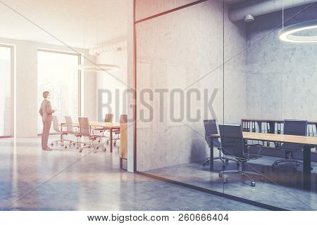 Young Businessma Standing In Industrial Style Conference Room Interior With Concrete And Glass Walls