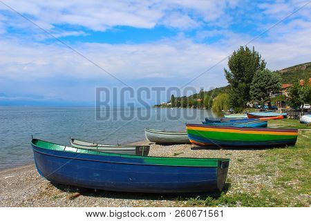 Wooden Colorful Boats On Beach Against Blue Sky