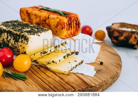 Cheese Halumi With Mint And Smoked Paprika On A Wooden Board With Tomatoes, Pepper And Rosemary