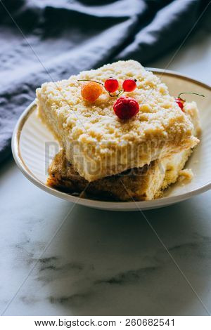 Pieces Of Cottage Cheese Cake With A Crumble Decorated With Raspberries And Red Currants On A White