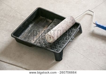 Roller For Painting Or Whitewashing Of Walls Is On A Paint  Tray.