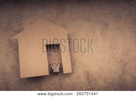 Litle Model Crown And Paper House On A Brown Background