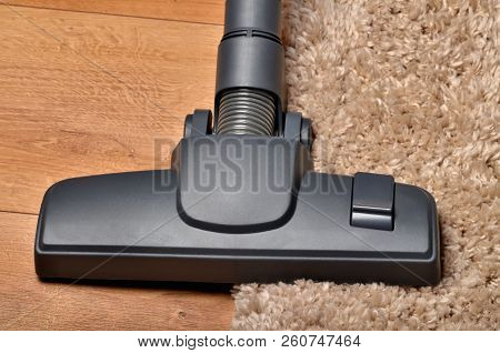 Close-up Of Head Of Vacuum Cleaner On Borderline Of Shaggy Carpet And Floating Floor