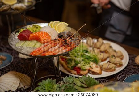 Mixed Sliced Fish Sashimi And Shrimps On Ice In Black Bowl. Sashimi Salmon Tuna Hamachi Prawn And Su