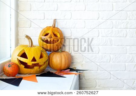 Few Orange Pumpkins Of Different Size Carved Into Jack O Lantern On Wooden Table. Background, Copy S