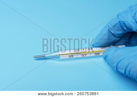Hand In Glove Holding A Thermometer Of Public Health And Medicine.