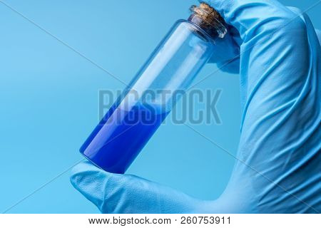 Close-up Of Glass Tube With Blue Fluid In Scientist Hand During Medical Test