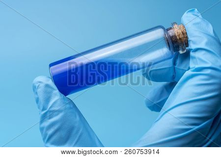 Close-up Of Glass Tube With Blue Fluid In Scientist Hand During Medical Test