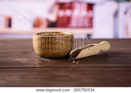 Lot Of Whole Fresh Brown Flaxseeds In A Scoop With Wooden Bowl With Grey Kitchen In Background
