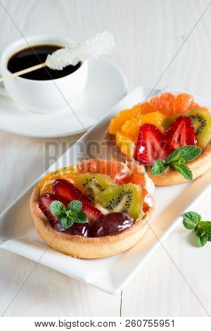 Fresh Fruit And Berry Tart Dessert With Toss Sugar On Wooden Background. Delicious Sweet Cake With R