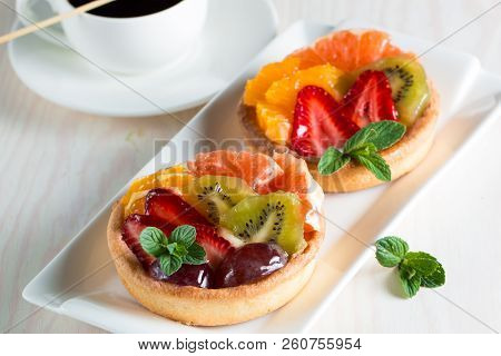 Fresh Fruit And Berry Tart Dessert With Toss Sugar On Wooden Background. Delicious Sweet Cake With R