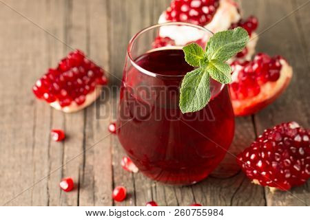 A Glass Of Pomegranate Juice With Fresh Pomegranate Fruits On Wooden Table. Vitamins And Minerals. H