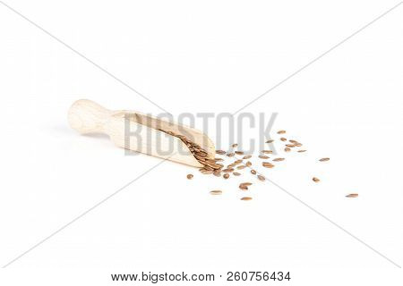 Lot Of Whole Fresh Brown Flaxseeds With Wooden Scoop Isolated On White Background