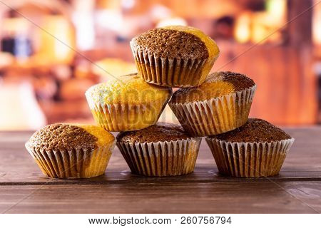 Group Of Six Whole Fresh Baked Marble Muffin With Rustic Wood Kitchen In Background