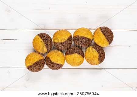 Group Of Eight Whole Fresh Baked Marble Muffin Flatlay On White Wood