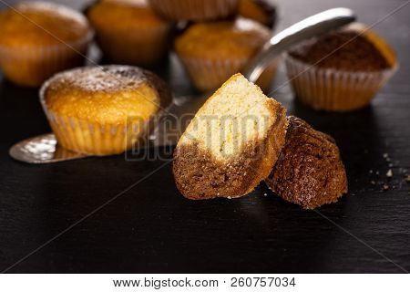 Group Of Lot Of Whole Two Halves Of Fresh Baked Marble Muffin On Silver Cake Server On Grey Stone
