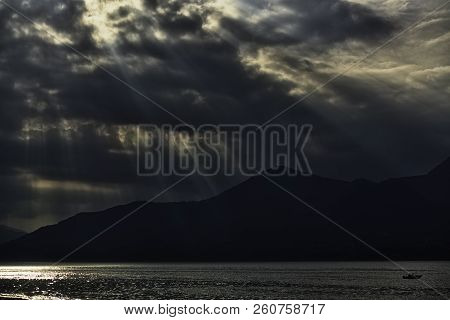 Backlight Panorama With Sunbeams At Sunset Over The Mountains And Maggiore Lake