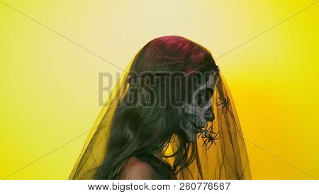 Halloween, Girl With Make-up Skeleton On Half Face, Dressed As Witch, Posing On Bright Yellow Backgr