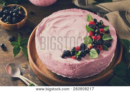 Cake With Black Currant Cream Souffle And Biscuit On A Table In A Rustic Style. Toned Image.