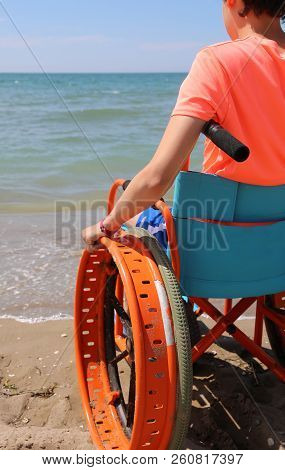 Young Boy By The Sea On The Wheelchair In Summer