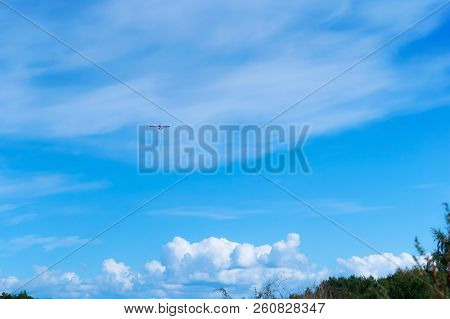 Glider In The Sky, A Small Aircraft Soars In The Blue Sky
