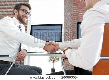 handshake financial partners sitting at Desk