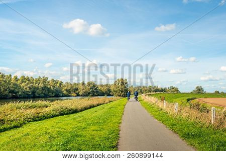 Older Man And Woman Cycle On A Curved Cycle Path On A Dike On The Edge Of The Dutch National Park De