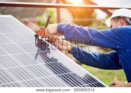 Process Of Connecting Solar Photo Voltaic Panel By Professional Technicians Outdoors On Bright Sunny