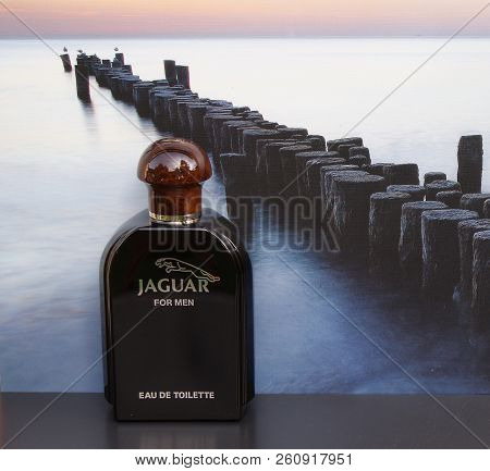 Jaguarfor Men, Eau De Toilette, Large Perfume Bottle In Front Of The Picture Of A Groyne In The Sea