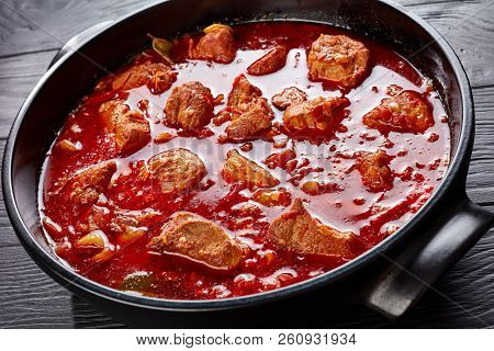 Hot Red Chile And Pork Stew Or Carne Adobada In A Dutch Oven On A Black Wooden Table, Mexican Cuisin