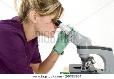 Técnico de laboratório jovem bonita olhando através do microscópio.