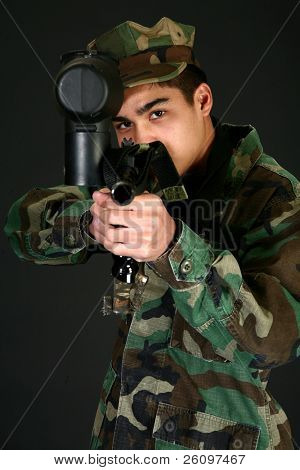 Attraktive Filippinsk 16-årig dreng i camo gear sigter paintball riffel.