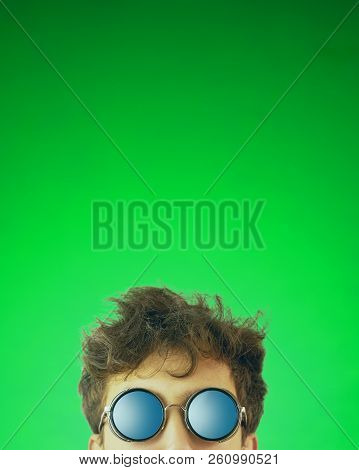 Man Looks Out. Guy With Glasses Looking At Camera On Green Background. Copy Space For Text. Crop 4x5
