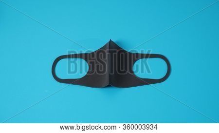 Black Face Mask Help To Protect Covid-19 Virus And Dust And Other Particle On Blue Background.