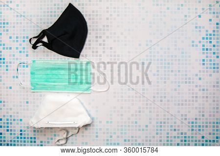 Different Types Of Protective Face Masks On Checkered Background. Fabric Mask, Medical Mask Ar Respi