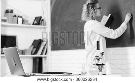 Back To School. Student Girl Writing Answer At Blackboard. Beaker And Microscope. Student Doesnt Use